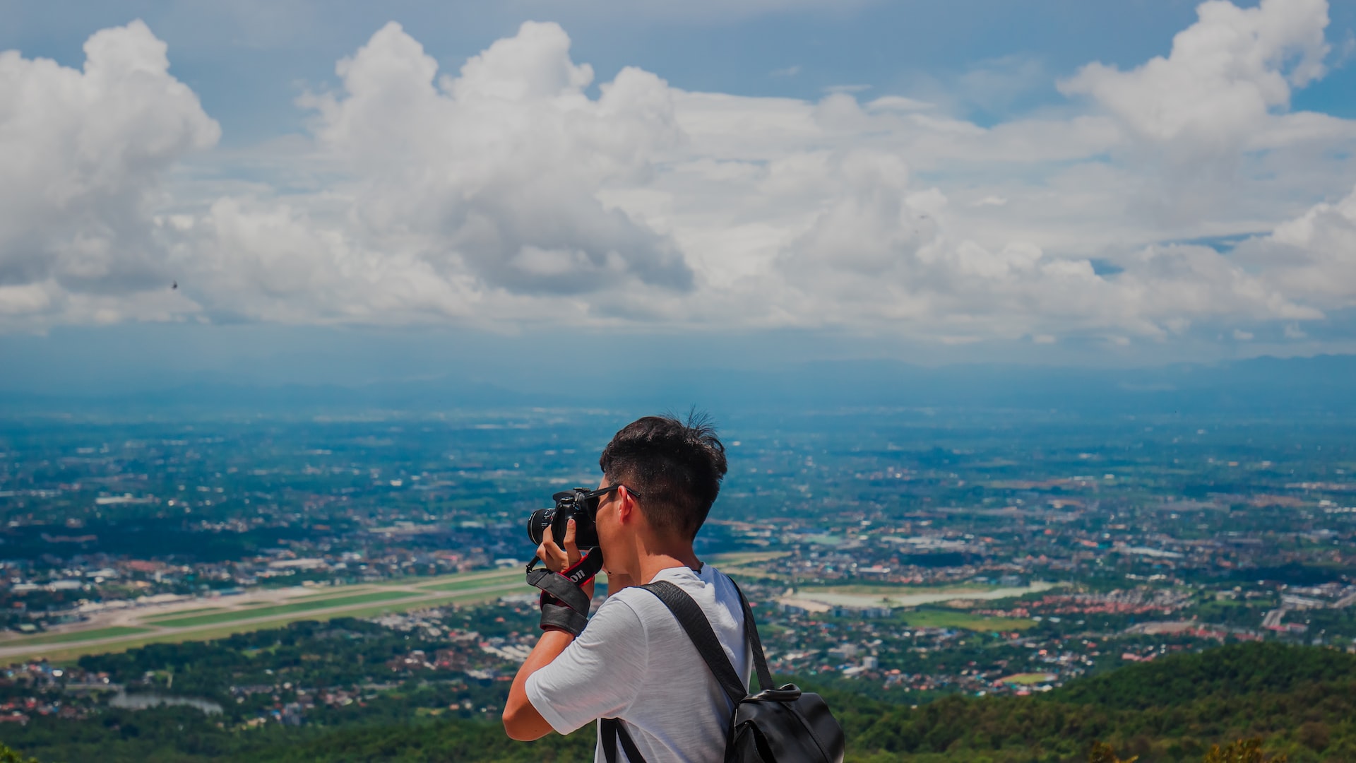 A tourist in Chiang Mai with the city's airport in the background